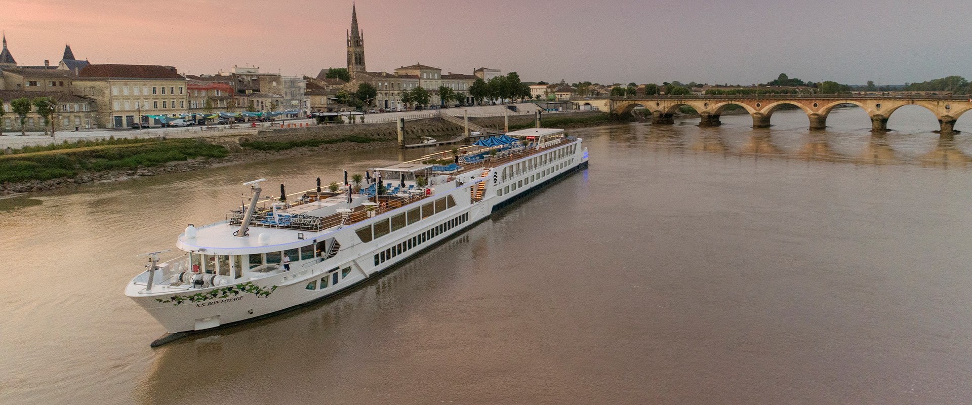 Uniworld S.S. Bon Voyage river cruise ship approaching a historic French town