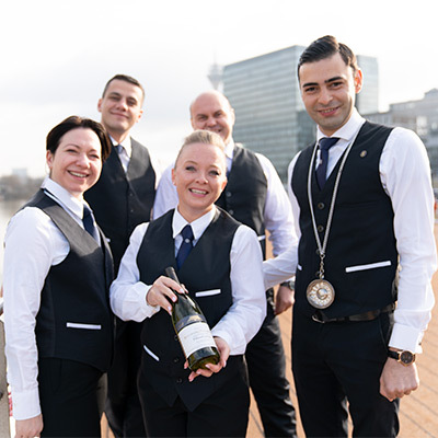 Uniworld crew with a bottle of champagne